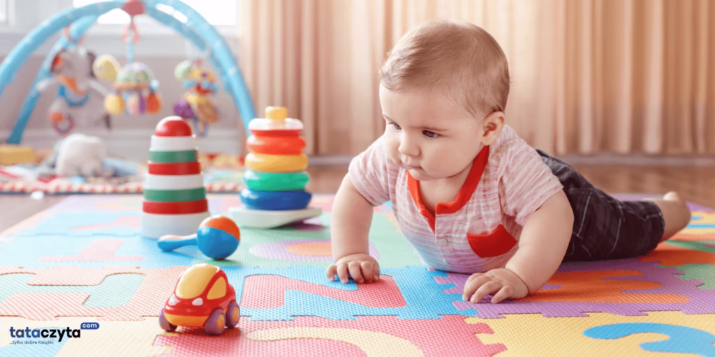 Rozwój dziecka – niemowlę bawiące się na kolorowej macie edukacyjnej z zabawkami stymulującymi zmysły.