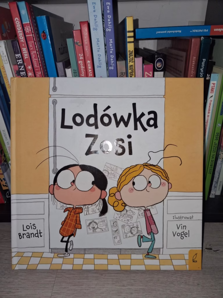Okładka książki „Lodówka Zosi” Lois Brandt, przedstawiająca dwie dziewczynki stojące przy lodówce; historia o empatii, przyjaźni i odwadze rozmawiania o trudnych emocjach.